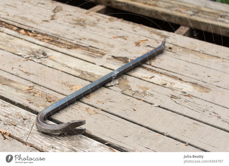 Holzdeck mit fehlendem Brett, das mit einem Brecheisen aufgehebelt wurde; Ersetzen von verrottendem Holz Brechstange Stemmeisen abreißen. ersetzen. Schiffsdeck