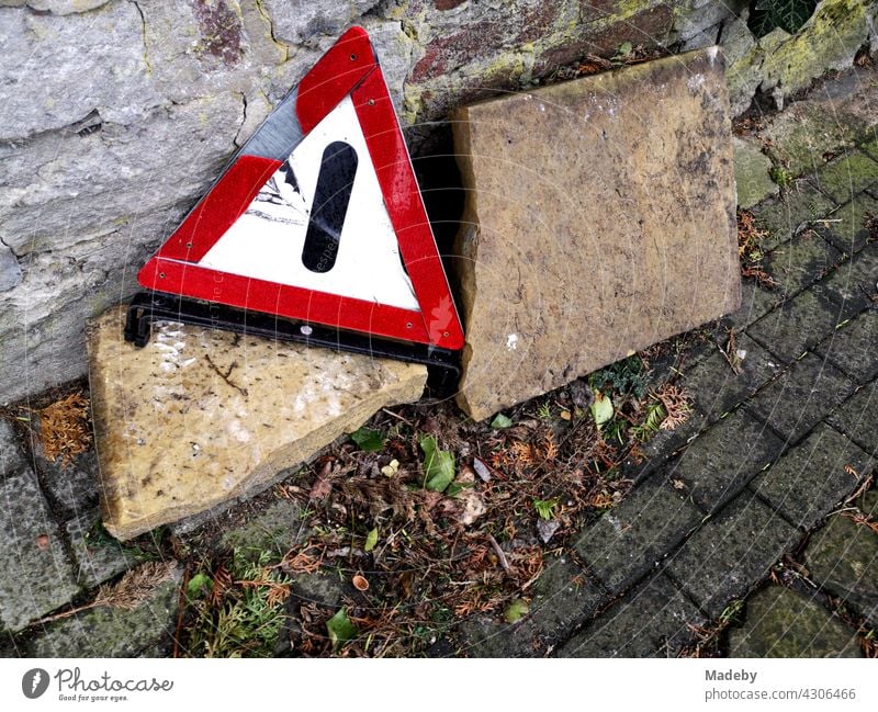 Kaputtes altes Warndreieck am Straßenrand vor einer alten Mauer im Herbst in der Altstadt von Oerlinghausen bei Bielefeld im Teutoburger Wald in Ostwestfalen-Lippe