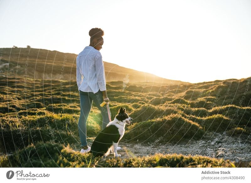 Frau mit Hund beim Spaziergang in der Natur Glück Haustier Liebe Tier Nachlauf Landschaft Begleiter Freund schwarz Afroamerikaner loyal Besitzer Lifestyle