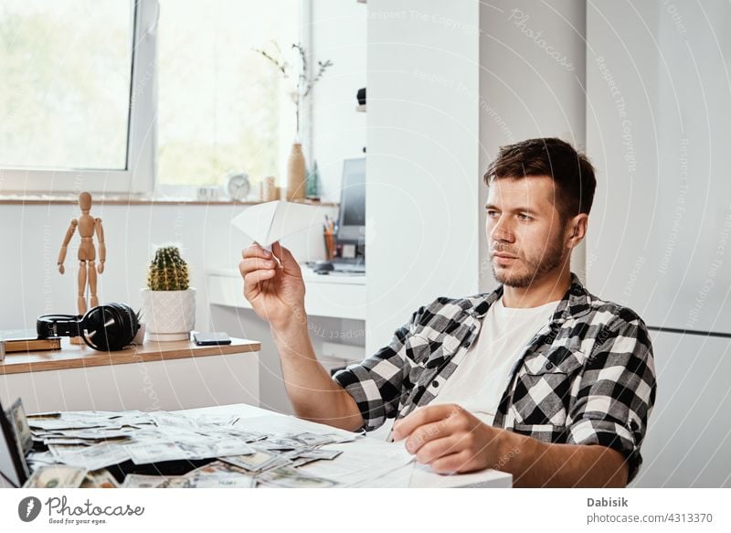 Mann mit Laptop und Dollar-Banknoten spielt mit Papier Ebene freiberuflich Business prokrastinieren abgelegen online Arbeit heimwärts LAZY Computer planen