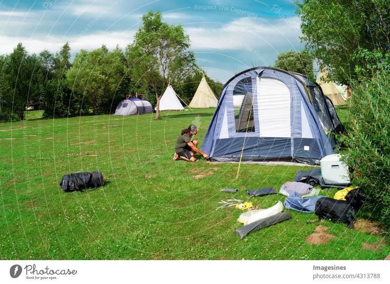 Zelten - Camping. Mann baut im Sommer ein Zelt auf einer Wiese auf aktiv Aktivität Erwachsene Abenteuer im Freien Lifestyle Campingplatz Landschaft Tag