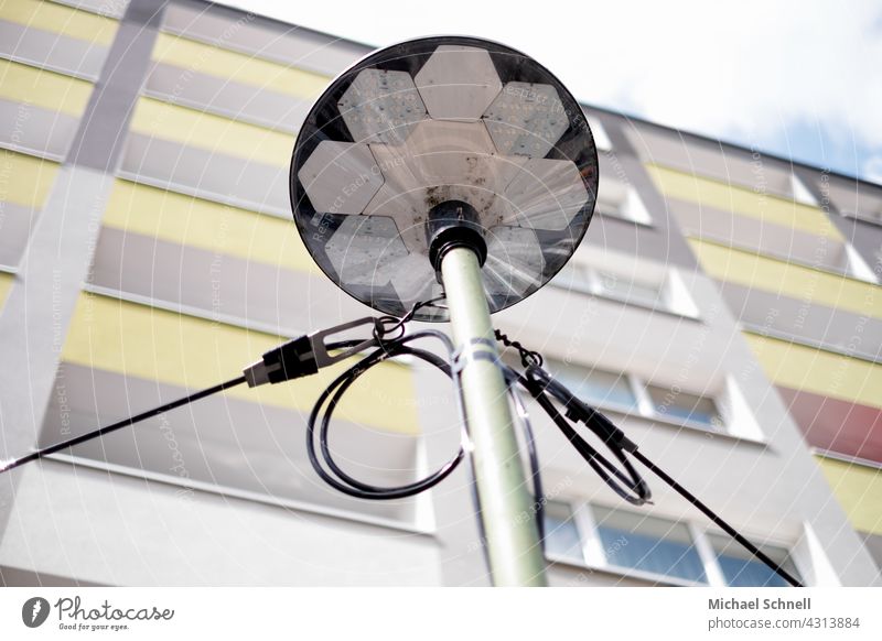 Laterne vor einem mehrgeschossigem Wohnhaus Leben Stadtleben Haus Häusliches Leben Fassade Wohnhochhaus Mehrfamilienhaus Licht leuchte