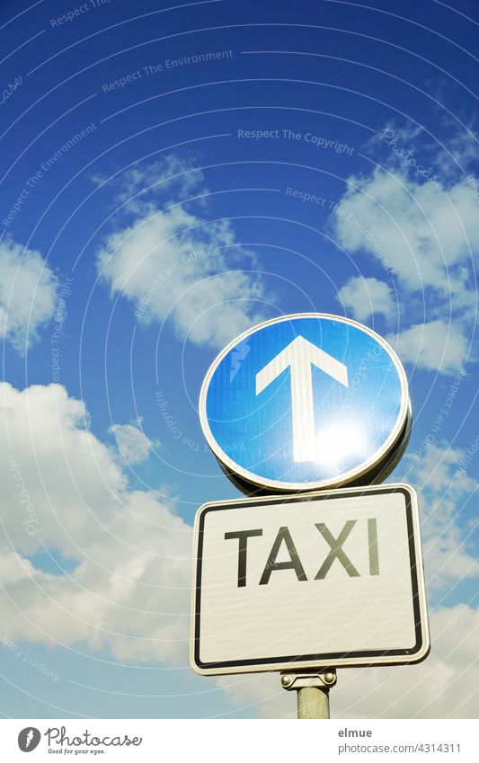 Verkehrszeichen " Vorgeschriebene Fahrtrichtung geradeaus" und Schild " TAXI " solitär vor leichtbewölktem Himmel / VZ 209-30 / himmelwärts