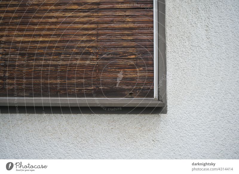 Fenster und geschlossener Fensterladen aus Holz in einer Fassade als Detail Ausschnitt Sanierung alt klassische Laden Rolladen Gebäude Wand Menschenleer