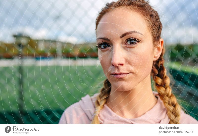 Seriöse junge Sportlerin mit Boxerzöpfen schaut in die Kamera ernst Athlet Boxerflechten schauende Kamera Gesicht Textfreiraum Nahaufnahme trotziger Blick