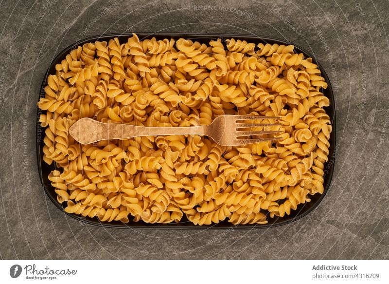 Besteck und rohe Nudeln auf dem Tablett Gabel Messer Spätzle Tisch Spiralnudel Mittagessen Attrappe Zusammensetzung Lebensmittel Küche Mahlzeit Utensil