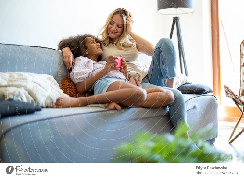 Mutter und Tochter zusammen zu Hause Kind Familie multiethnisch gemischte Rassenfamilie vielfältige Familie Vielfalt Afro-Look heimwärts echte Menschen