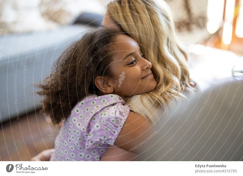 Mutter und Tochter umarmen zu Hause Kind Familie multiethnisch gemischte Rassenfamilie vielfältige Familie Vielfalt Afro-Look heimwärts echte Menschen