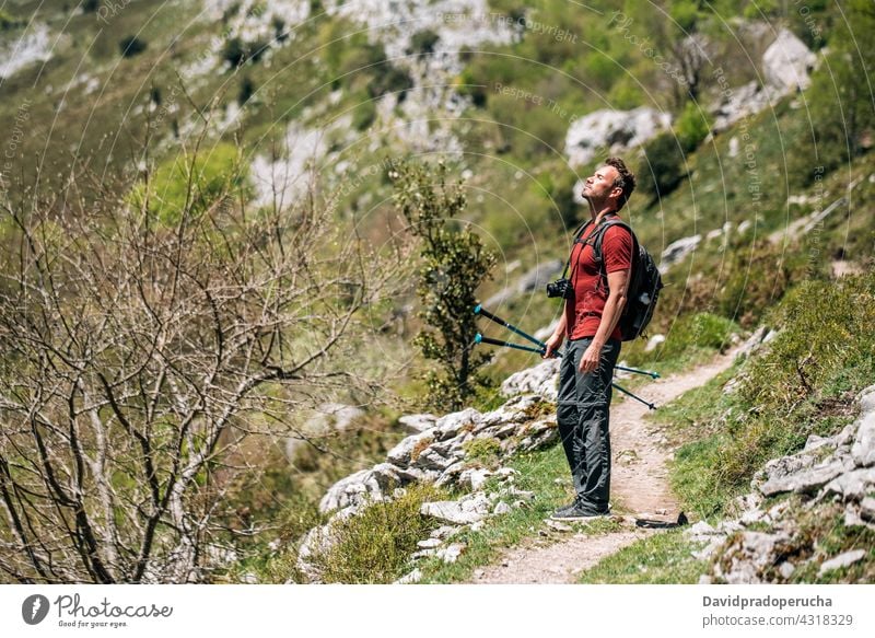 Reisender mit Rucksack und Fotokamera am felsigen Hang Wanderer Berghang bewundern Natur Trekking Mast Tierwelt Landschaft reisen Klippe Fotoapparat Tourismus