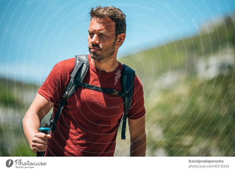 Männlicher Wanderer mit Trekkingstöcken in bergigem Terrain Tourist Wanderung Mast Hochland Rucksack Felsen Tourismus Natur Reisender reisen Abenteuer erkunden