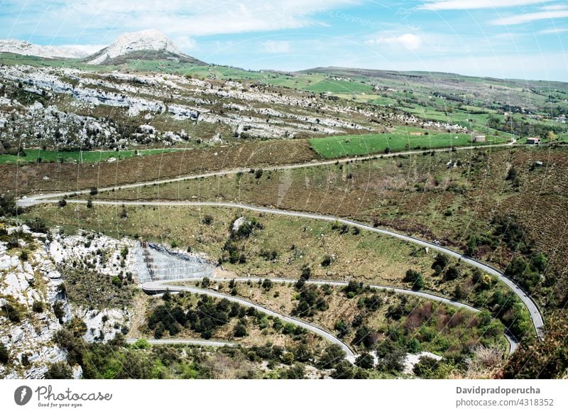 Sich schlängelnde Fahrbahn durch grüne Hügel im Hochland Serpentine Kurve Straße Berghang Berge u. Gebirge Natur Tal Geologie Gelände Asphalt Landschaft Route