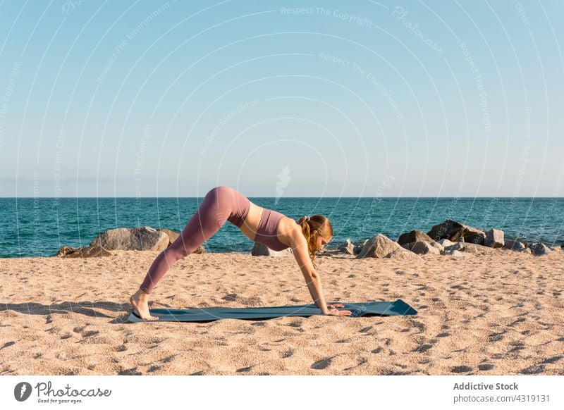 Frau macht Yoga in Downward Facing Dog Pose am Strand üben Harmonie nach unten gerichtete Hundehaltung Dehnung beweglich Asana MEER Sand Gesundheit