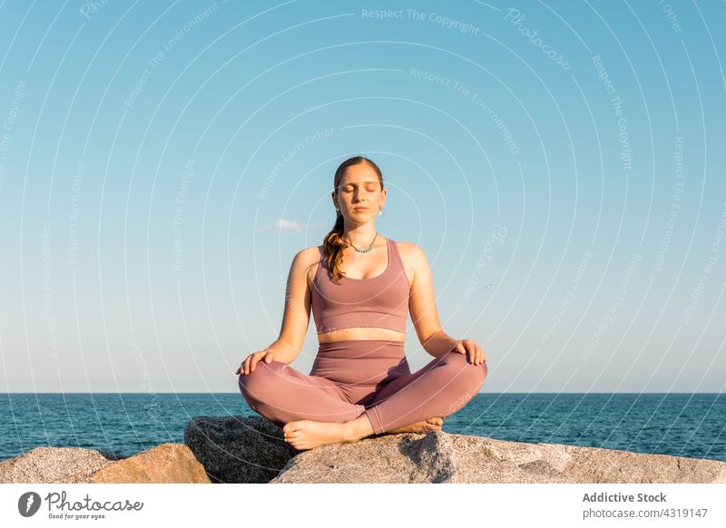 Frau übt Yoga in Lotus-Pose am Strand meditieren Asana Zen üben Achtsamkeit Gesundheit Ufer Gleichgewicht padmasana Windstille sich[Akk] entspannen Wellness