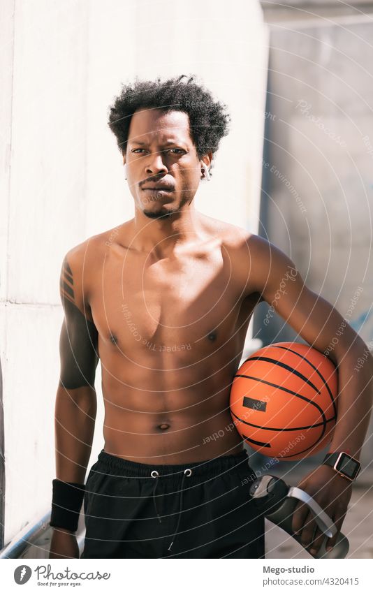 Afro-Athlet Mann hält einen Basketball-Ball im Freien. Sport urban sportlich Stehen genießen Ausdruck aktiv Hand Übung Erholung Fitness Training Blick Aktivität