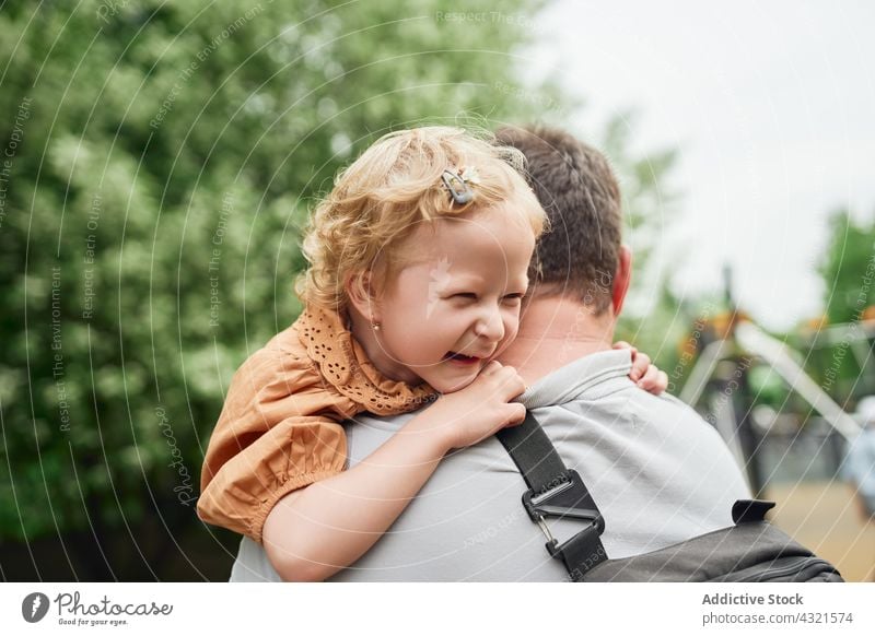 Vater kuschelt mit Kind auf Spielplatz Tochter Umarmung Liebe Umarmen niedlich heiter Zusammensein Eltern Mädchen Glück Kindheit Mann wenig Papa spielen