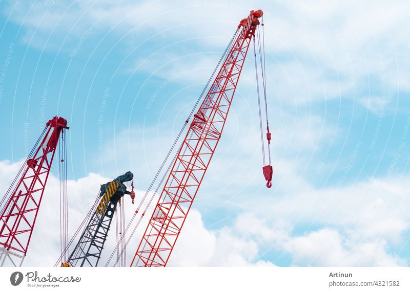 Raupenkran gegen blauen Himmel und weiße Wolken. Immobilien-Industrie. Red Raupenkran Verwendung Haspel heben Ausrüstung in Baustelle. Kran zu vermieten. Kran-Händler für Baugeschäft.