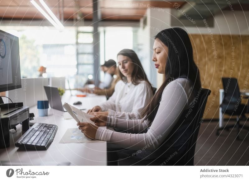 Frauen lesen Dokumente im Büro Kollege Diagramm asiatisch Schriftstück Training Mitarbeiterin Zusammensein Tabelle rassenübergreifend Arbeit Business