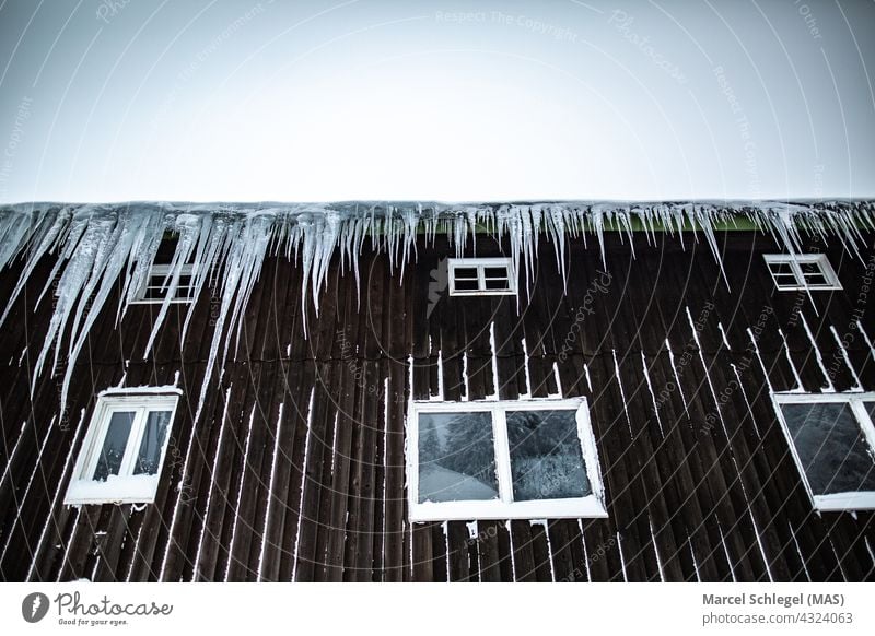 Schneebedeckte und mit Eiszapfen gerahmte Berghütte aus Holz Holzhütte Winterhütte Außenaufnahme Berge u. Gebirge Hütte Farbfoto Ferien & Urlaub & Reisen