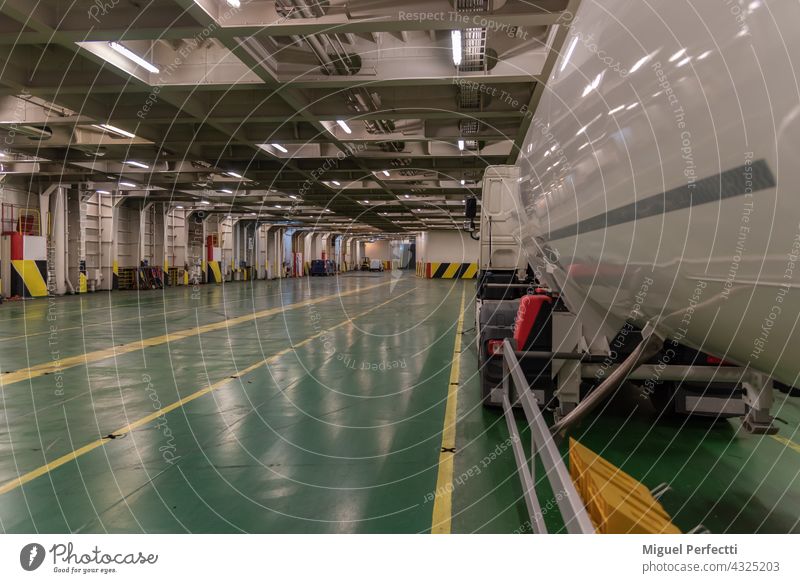 Blick in den Laderaum eines Fährschiffs mit einem Tankwagen. Lastwagen Halt Fähre Boot Lagerhalle vertäut im Inneren Schiff Anhänger Seereise gefährliche Güter