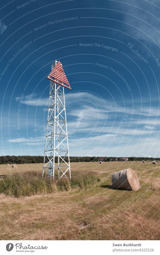 Seezeichen steht auf Feld neben einer Heurolle vor blauen Himmel Schifffahrt Blauer Himmel Sommer Heuballen Ernte Herbst sommerlich Wolken Turm dreckig Dreieck