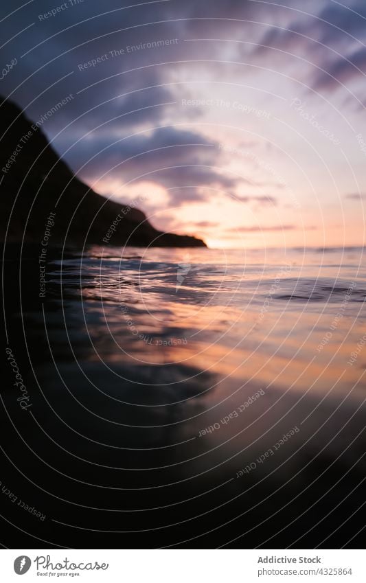 Wogendes Meer mit Berg im Hintergrund MEER winken schäumen Sonnenuntergang Meereslandschaft Wasser abstrakt platschen Abend malerisch Natur marin Dämmerung