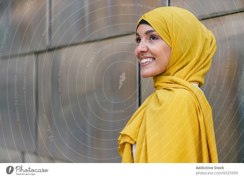 Stilvolle Muslima mit gelbem Kopftuch in der Stadt Frau Hijab Großstadt trendy Lächeln charmant Vorschein Tradition ethnisch muslimisch Straße Kultur Religion