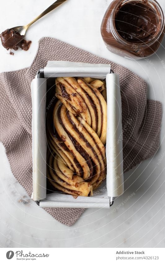 Babka-Dessert mit Schokoladenüberzug in einer Auflaufform babka Bäckerei ungekocht Küche roh Teigwaren Kuchen Belag Paste Tisch Backpapier Gebäck Bestandteil