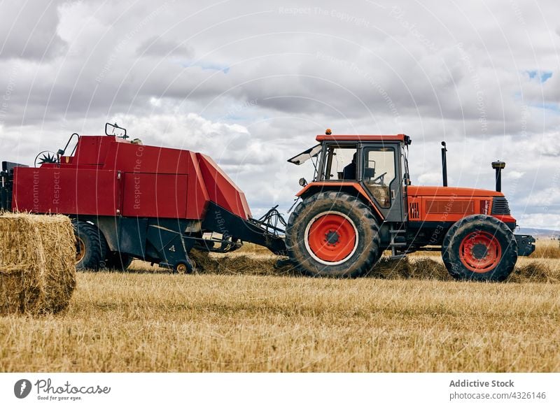 Traktor und Heuhaufen auf dem Feld rollen Heugarben getrocknet Ackerbau ländlich Sommer Landschaft Maschine Fahrzeug Verkehr Umwelt Bauernhof modern Saison