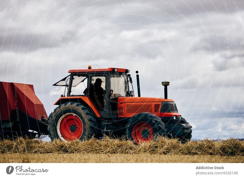 Traktor und Heuhaufen auf dem Feld rollen Heugarben getrocknet Ackerbau ländlich Sommer Landschaft Maschine Fahrzeug Verkehr Umwelt Bauernhof modern Saison