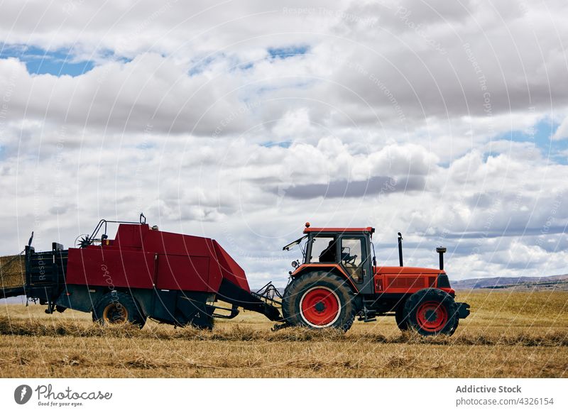 Traktor und Heuhaufen auf dem Feld rollen Heugarben getrocknet Ackerbau ländlich Sommer Landschaft Maschine Fahrzeug Verkehr Umwelt Bauernhof modern Saison