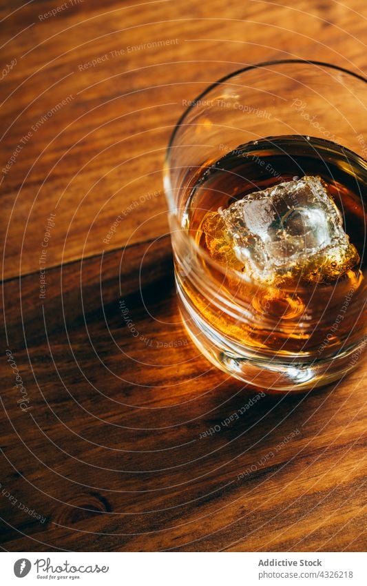 Glas mit Whiskey und Eis Tisch Tasse kalt trinken Alkohol dunkel Würfel Kristalle Container Getränk liquide cool Schnaps Holz Nutzholz hölzern Party Reichtum