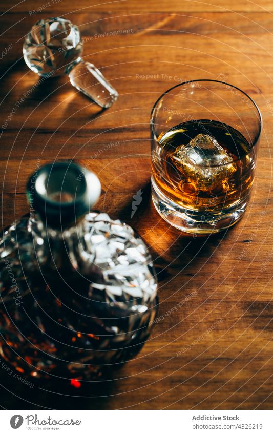 Glas Whiskey neben Karaffe Tisch Karaffen Tasse kalt Eis trinken Alkohol dunkel Kristalle Flasche Container Getränk liquide cool Zusammensetzung Schnaps Holz