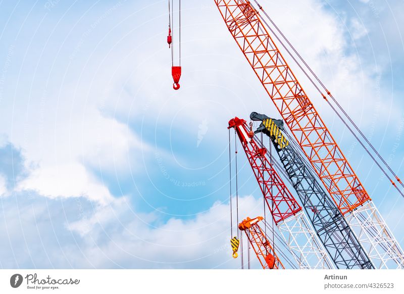 Raupenkran gegen blauen Himmel und weiße Wolken. Immobilien-Industrie. Red Raupenkran Verwendung Haspel heben Ausrüstung in Baustelle. Kran zu vermieten. Kran-Händler für Baugeschäft.