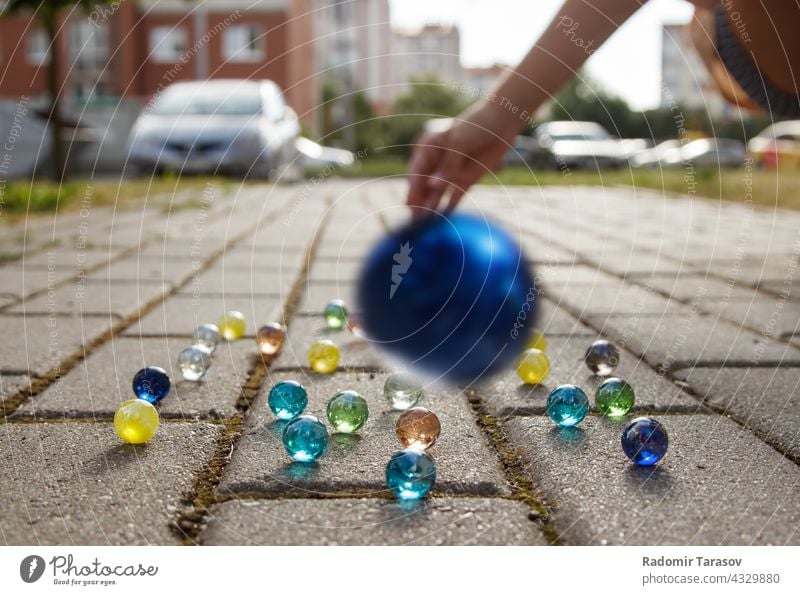 Mädchen wirft eine Glaskugel auf den Gehweg Ball Werfen werfen spielen Menschen Spaß Spiel schön Freizeit Aktivität Entertainment gelb spielerisch