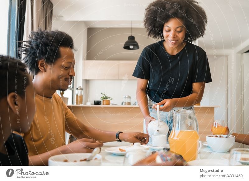 Familie beim gemeinsamen Frühstück zu Hause. Morgen Zusammensein Kind niedlich Gesundheit Lebensmittel Servieren gemischtrassig Afroamerikaner Person heimisch