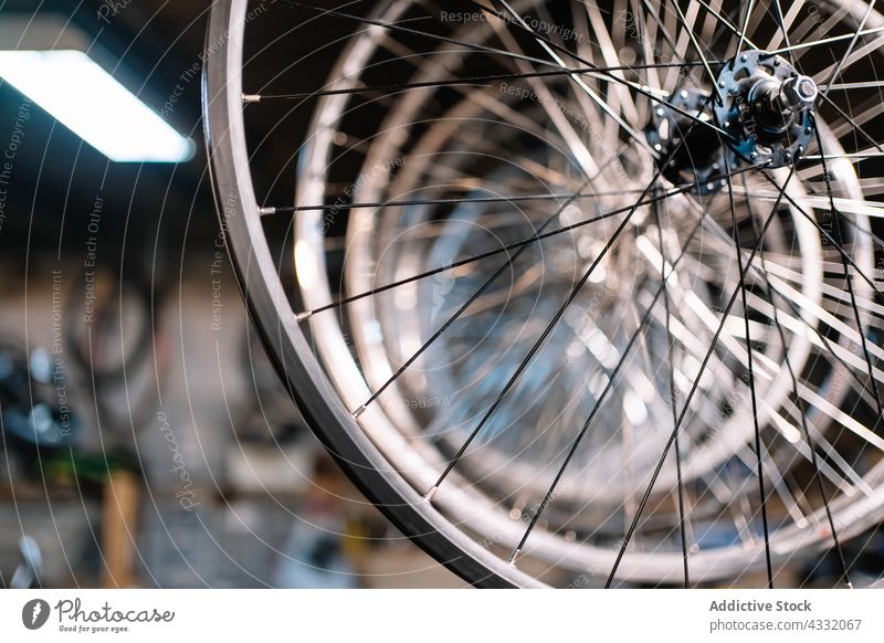 Fahrradräder auf einem Ständer in der Werkstatt Rand Rad Reihe Metall Reparatur Dienst Stahl hängen Gerät Ablage glänzend Detailaufnahme Element viele