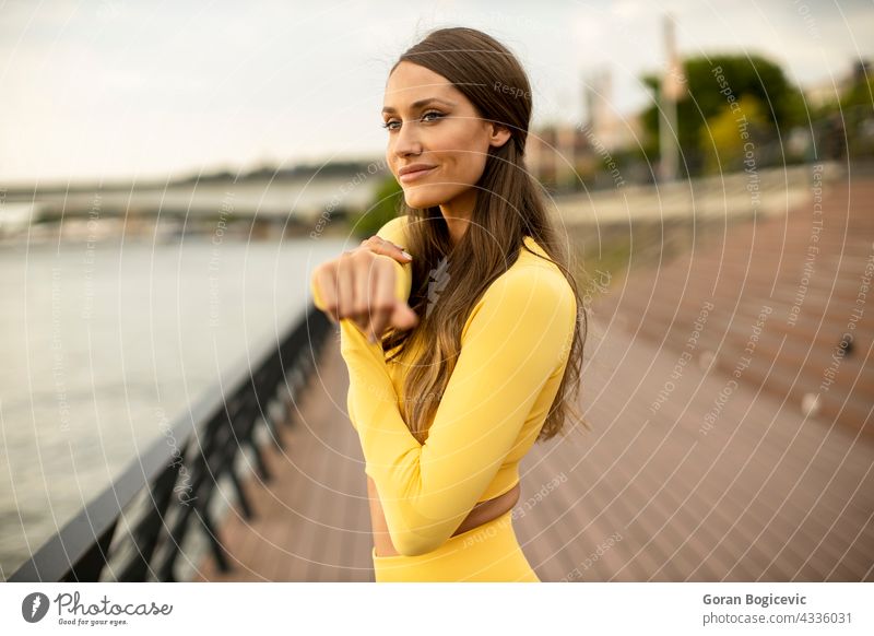 Junge Frau streckt sich am Flussufer jung Joggen Training Fitness nach oben Läufer Athlet Menschen Lifestyle Gesundheit Person Körper Sommer Beine