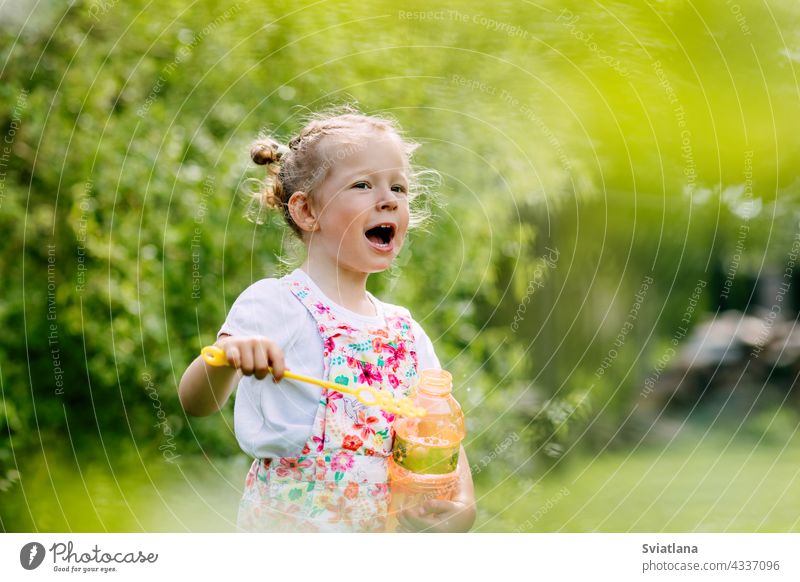 Charmantes Baby Mädchen mit Seifenblasen im Park oder Garten wenig Blasen Freude Kindheit grün Spaß Porträt Schlag schön Sommer spielen niedlich Natur lustig