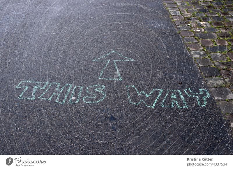 pfeil und this way auf den boden gemalt richtung wegweiser geradeaus richtungsweiser richtungsweisend da lang route orientierung hinweis zeichen symbol ziel