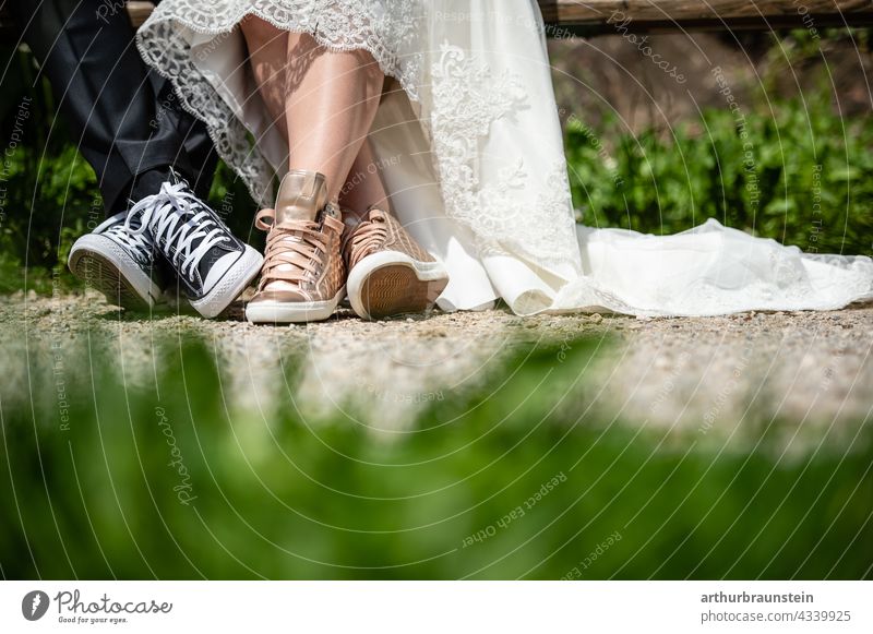 Junges Hochzeitspaar in Sneaker Schuhen sitzt auf einer Bank in der Natur hochzeit Liebe Paar Außenaufnahme Liebespaar Partnerschaft Ehe 2 Zusammensein Frau