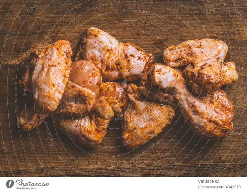 Marinierte Hähnchenteile zum Grillen oder Braten auf Holzuntergrund. Ansicht von oben Hühnerstücke mariniert Grillrost Röstung hölzern Hintergrund Top-View