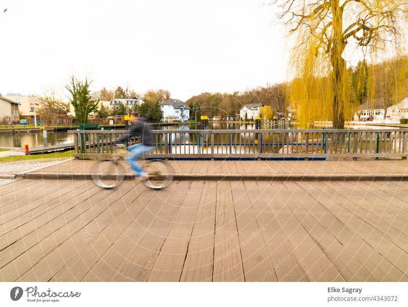 UNSCHÄRFE rasender Radfahrer rollt über die Brücke Brücke unscharf verschwommen Unschärfe abstrakt Licht Farbe urban Straße Bokeh im Freien defokussiert