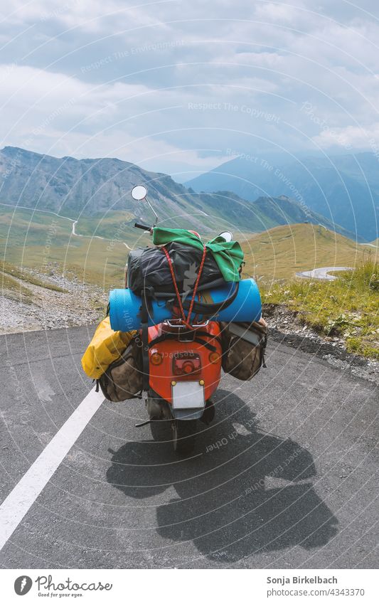 Überladener nostalgischer Motorroller parkt in den Hochalpen (Großglockner Hochalpenstraße), Österreich, im Sommer motorroller oldtimer beladen überladen gepäck