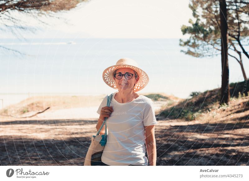 oman mit grauen Haaren am Strand während einer super sonnigen Tag, Senior Freiheit Konzept, Kopie Raum, entspannen und geistige Gesundheit Person Frau älter