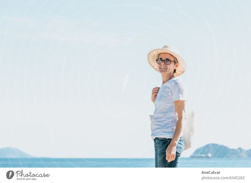 oman mit grauen Haaren am Strand während einer super sonnigen Tag, Senior Freiheit Konzept, Kopie Raum, entspannen und geistige Gesundheit Person Frau älter