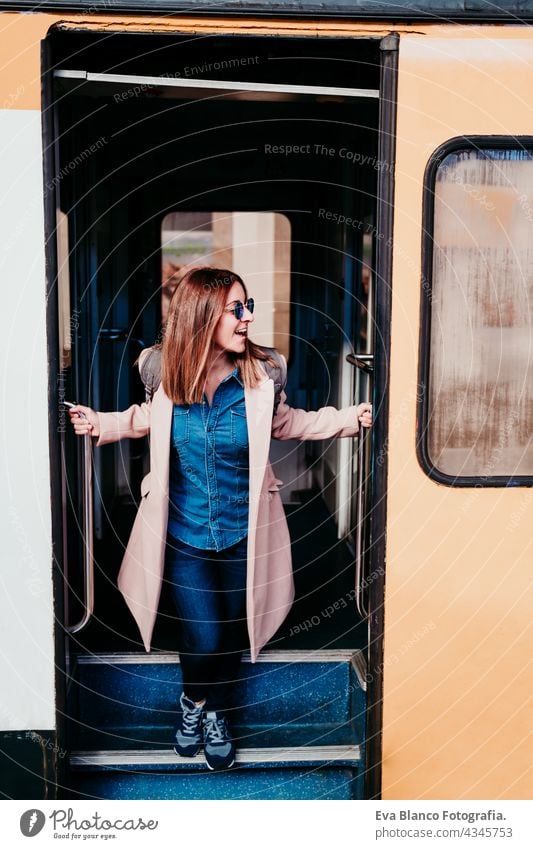 lächelnde junge Backpacker kaukasische Frau steht auf Wagen am Bahnhof. Reisen Konzept Handy reisen Kaukasier Glück Technik & Technologie Rucksack tagsüber