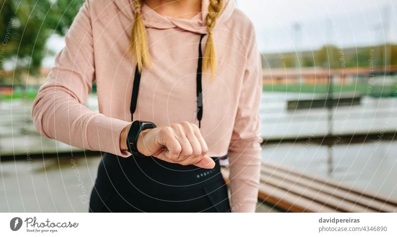 Junge Sportlerin sucht Aktivitätsarmband unkenntlich Frau Athlet Blick smartwatch Mittelteil Textfreiraum Schrittzähler Training Morgen Fitness aktiv attraktiv