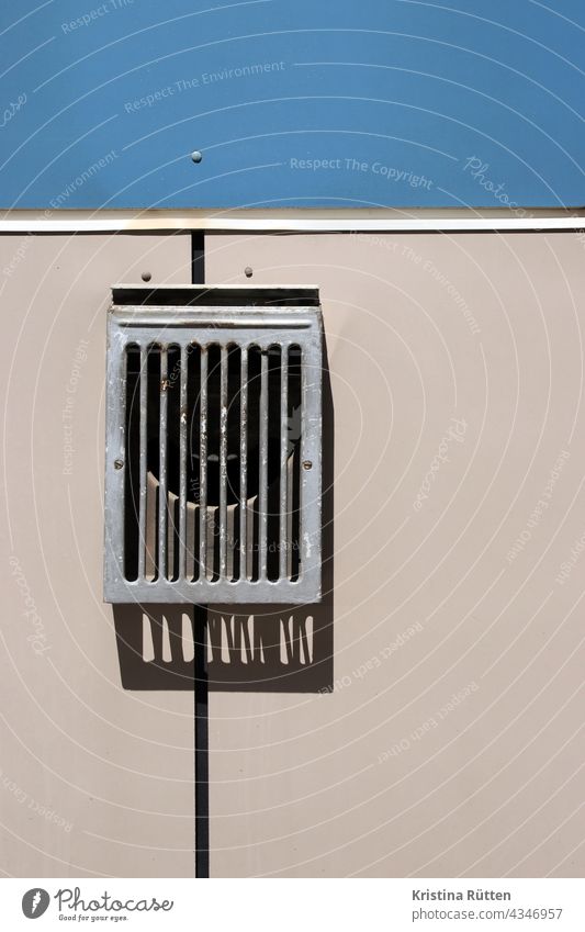 fassadenverkleidung mit lüftungsgitter dunstabzug abluft rohr öffnung mauerkasten belüftung ablufttechnik lüftungstechnik haus gebäude wand architektur detail