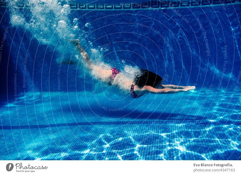 Kaukasische Frau Tauchen im Schwimmbad. Unterwasser-Ansicht. Sommerzeit und Urlaub Konzept unter Wasser Spaß Liebe Blauwasser sonniger Tag im Freien