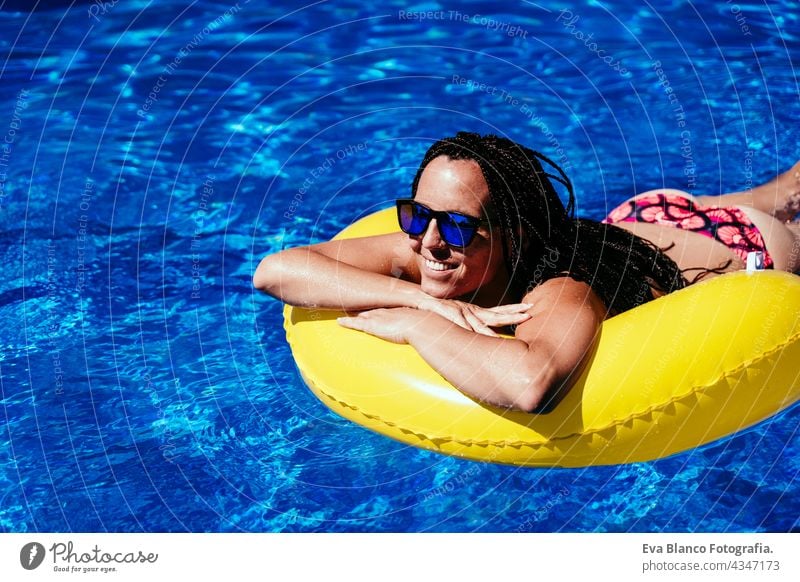 Draufsicht auf glückliche kaukasische Frau, die sich auf gelben Donuts aufblasbaren am Swimmingpool entspannt. Sommerzeit, Urlaub und Lebensstil Kaukasier